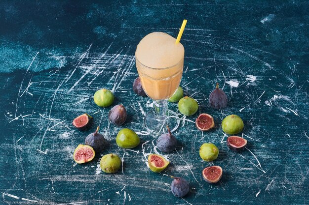 Figs with a cup of drink on blue.