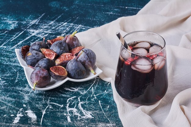 Figs with a cup of drink on blue.