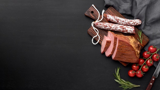 Fillet meat and salami on wooden board with copy-space