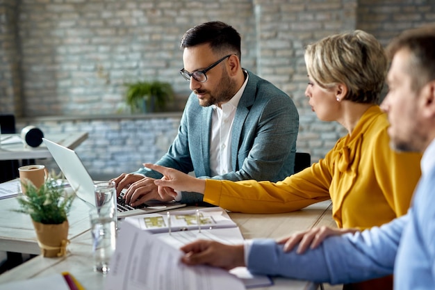 Free photo financial advisor working on a computer while having a meeting with a couple in the office