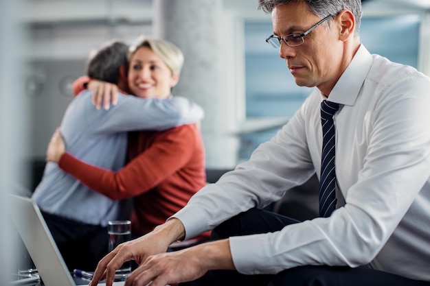 Free photo financial advisor working on laptop while having a meeting with clients in the office