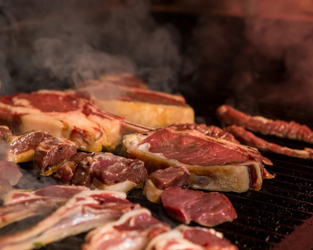 Finely cut lamb pieces are being cooked on an iron grill