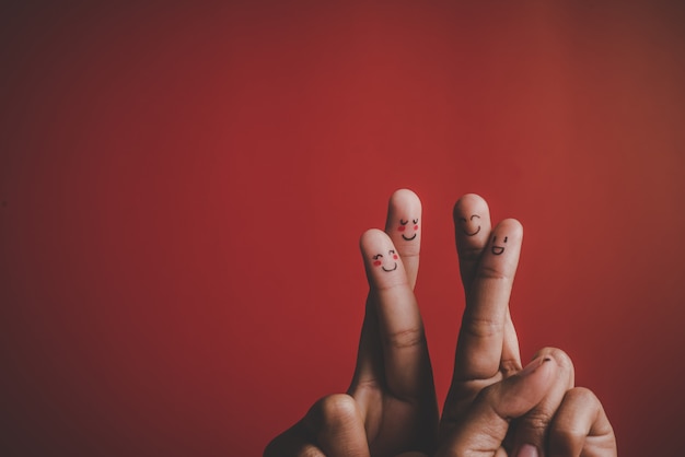 Finger with emotion on red background