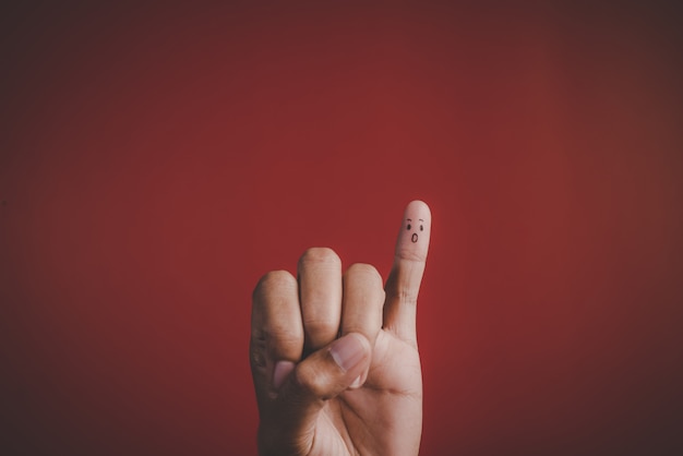 Free Photo finger with emotion on red background