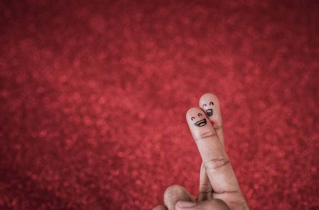 Finger with emotion on red background