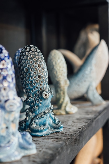 Free Photo finished pottery stands on a shelf in a pottery workshop. ceramic whales and octopuses