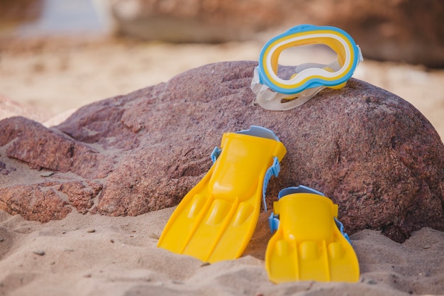 Free photo fins and diving goggles on a stone