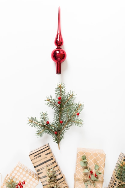 Free photo fir tree branch with christmas tree toy and gifts