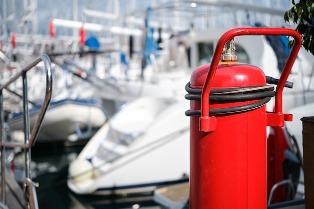 Free photo fire extinguisher closeup on the mooring of the yacht club blurred background providing fire protection and safety prevention