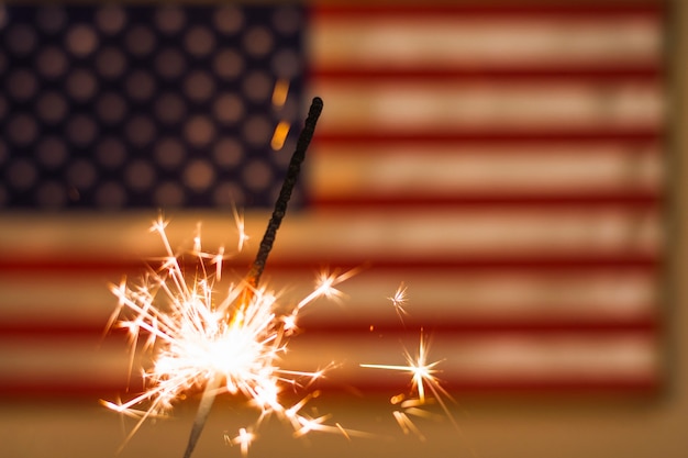 Fire of sparkler against defocused usa flag