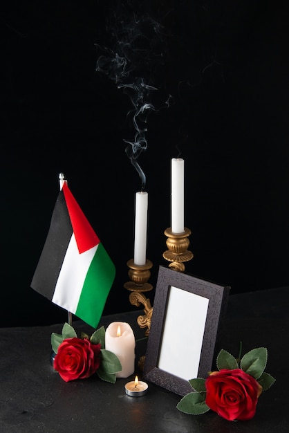 Free Photo fireless candles with palestinian flag and flowers on dark surface