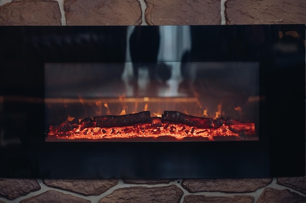 Fireplace with burning logs. Close-up of stony fireplace with burning or smoldering logs on fire.