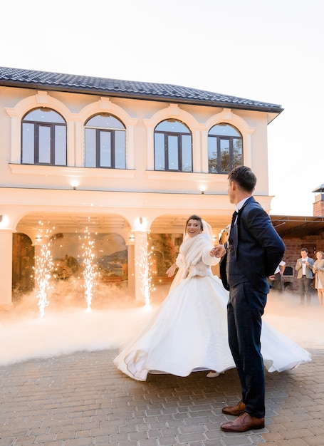 First dance on wedding couple in love outdoors surrounded with pyrotechnic effects