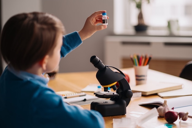 First grade boy studying at home, doing experiments