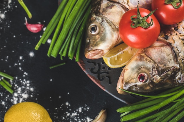 Fish heads with herbs, lemon and tomatoes with sea salt around