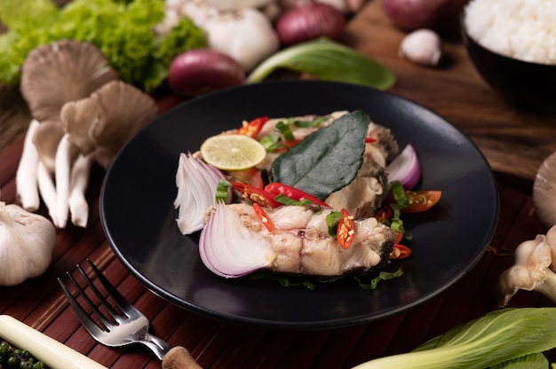 Fish salad with lime, chili, lemongrass, onions, red onions, parsley and kaffir lime leaves in the plate