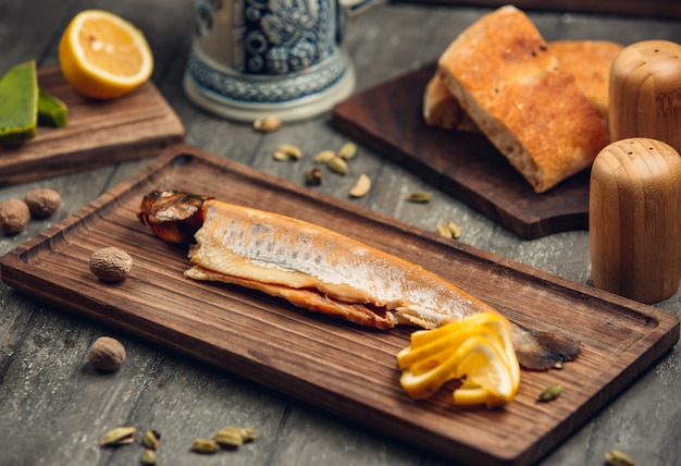 fish on the wooden board with lemon