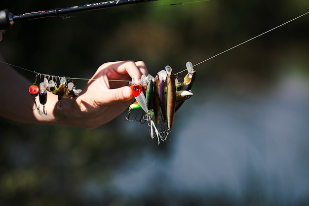 Fisherman's hand choosing bait on fishing line