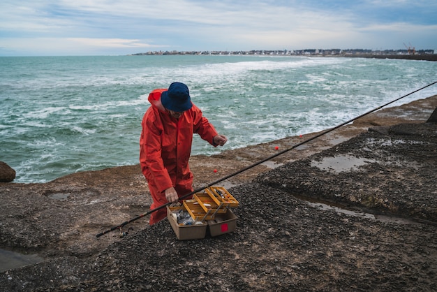 Free Photo fisherman with fishing equipment box.