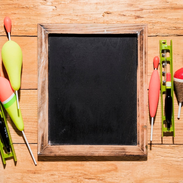 Free photo fishing floats with blank slate on wooden placard