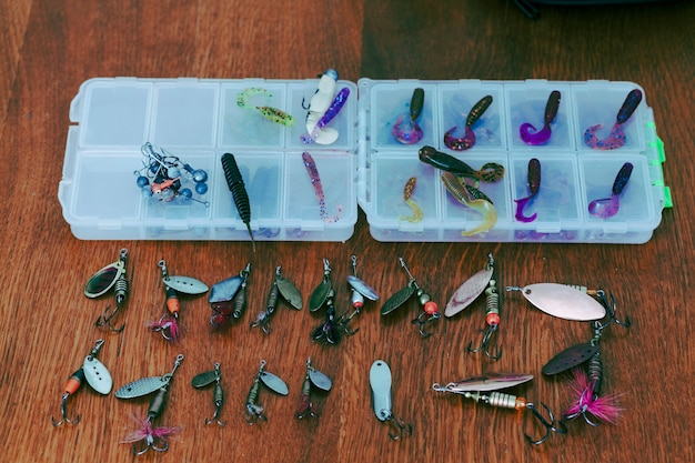 Free photo fishing lures with boxes on wooden desk