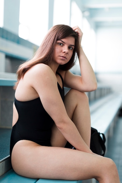 Fit female swimmer posing indoors