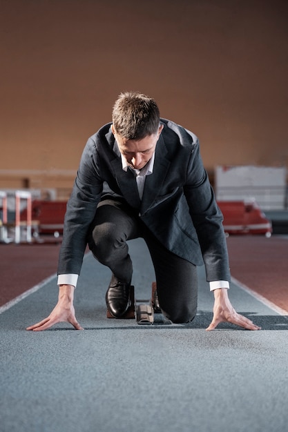 Free photo fit man ready to run in suit full shot