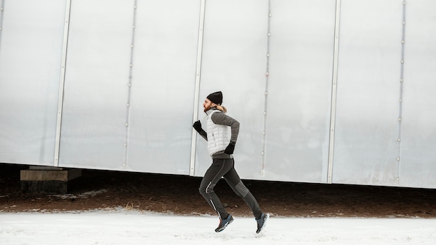 Free photo fit man running alone outdoors full shot