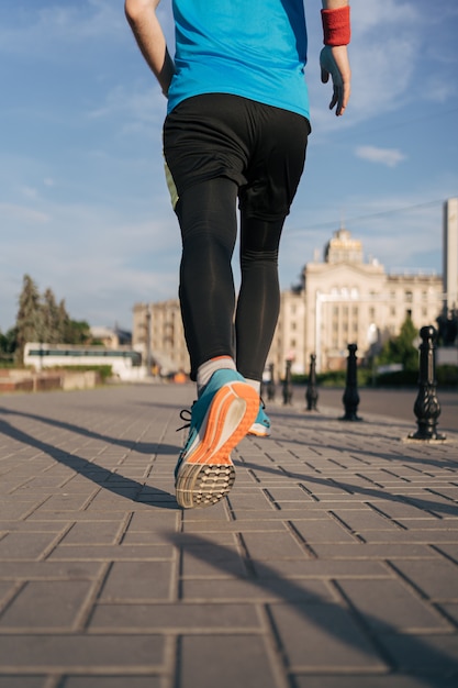 Fit man running legs in the city