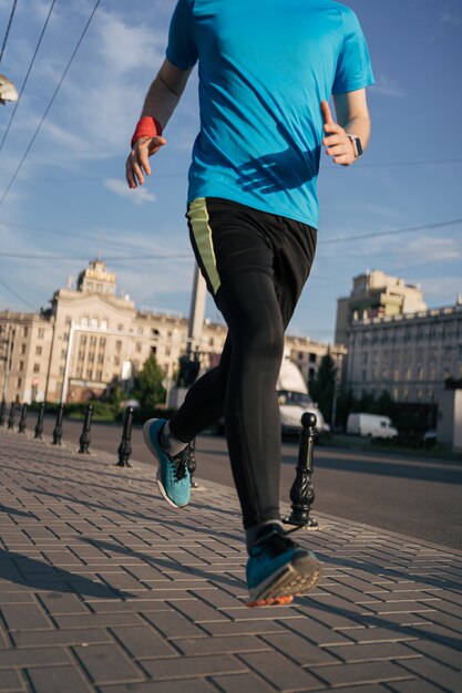 Fit man running legs in the city