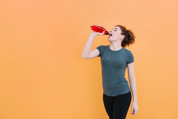 Free photo fit woman having red drink