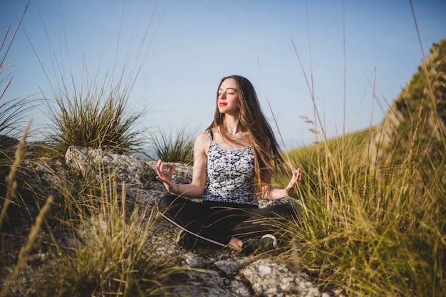 Free photo fit woman relaxing on rock