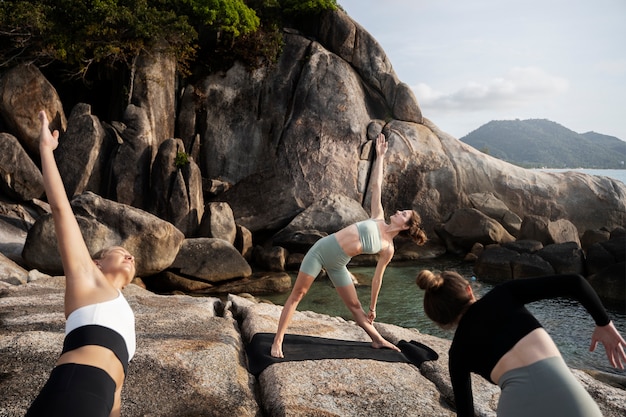 Free Photo fit women doing yoga in nature