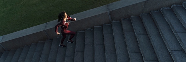 Free photo fit young woman climbing stairs