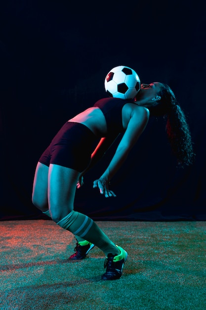 Free photo fit young woman playing football