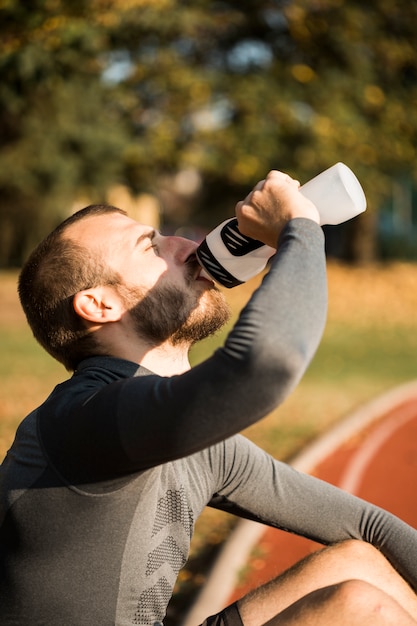 Free photo fitness boy drinking water