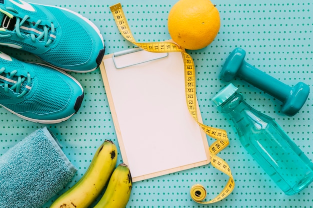 Fitness concept with clipboard, orange and shoes