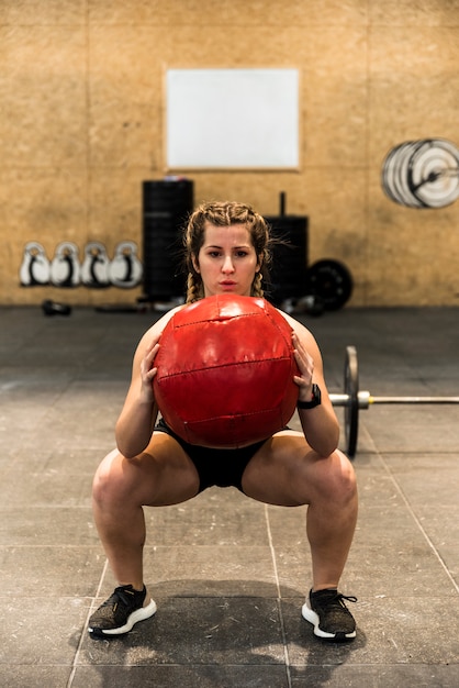 Free photo fitness girl lifting ball