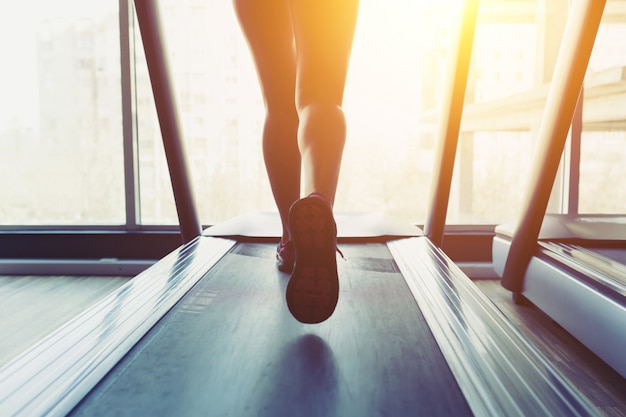 Free photo fitness girl running on treadmill