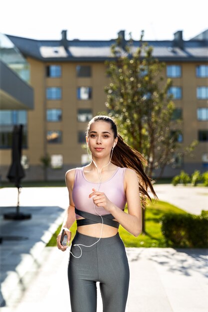 Fitness girl in the stylish sportswear doing running cardio workout in the morning