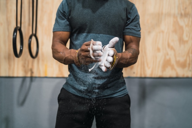 Fitness man rubbing hands with chalk magnesium powder.