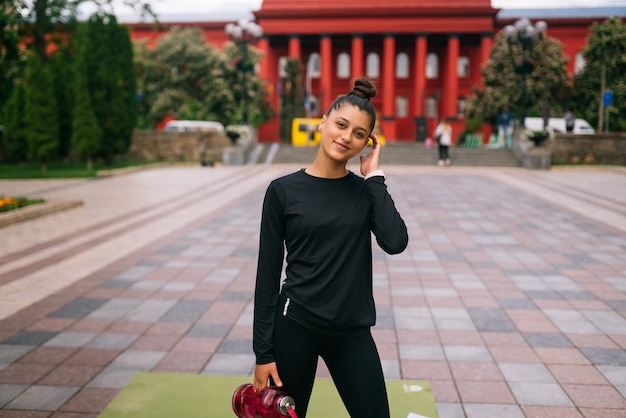 Free photo fitness model in sportswear posing on the city street