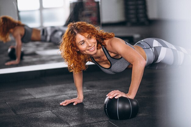 Fitness woman doing push-ups at the gym