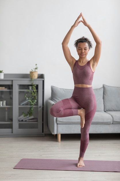 Free photo fitness woman doing yoga on a yoga mat at home