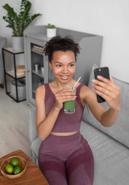 Free photo fitness woman taking a selfie while having a fruit juice