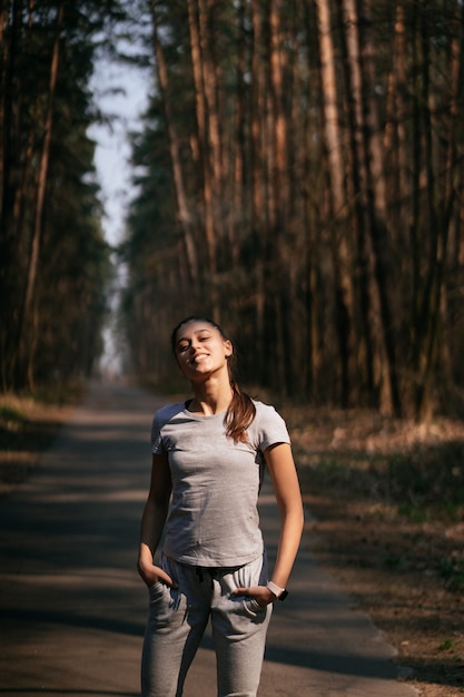 Free Photo fitness young woman walks in the park and posing for the camera