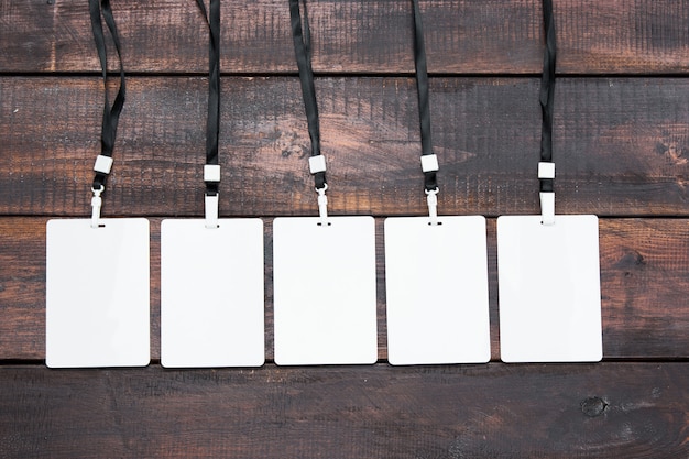 Free Photo the five card badges with ropes on wooden table