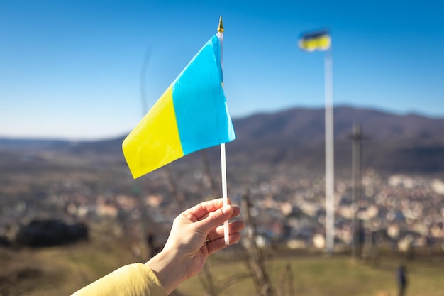 Flag of ukraine in female hands against the sky