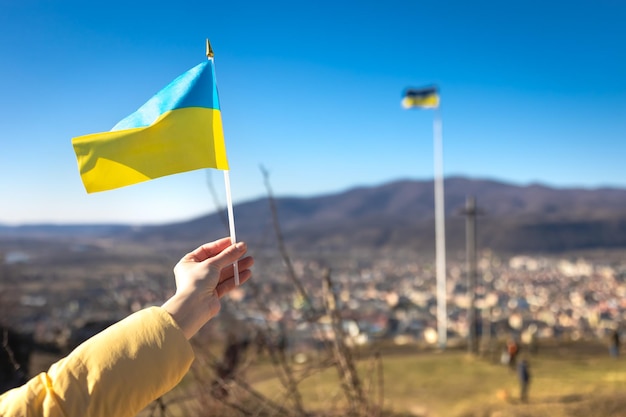 Flag of ukraine in female hands against the sky