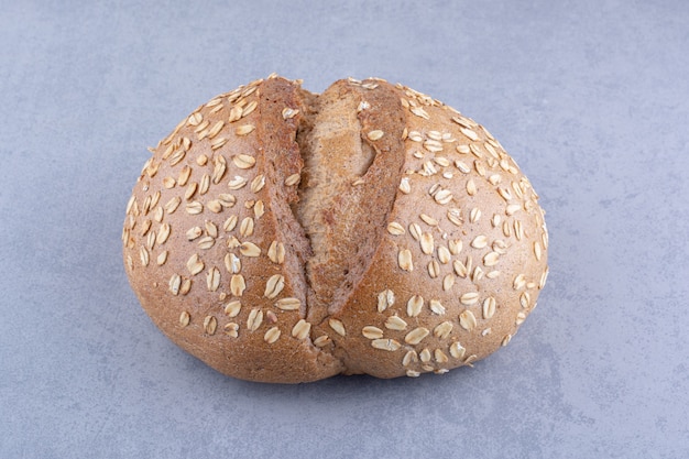 Flake covered loaf of bread on marble surface